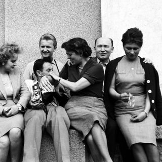 Group of people seated together, appearing joyous and celebratory.