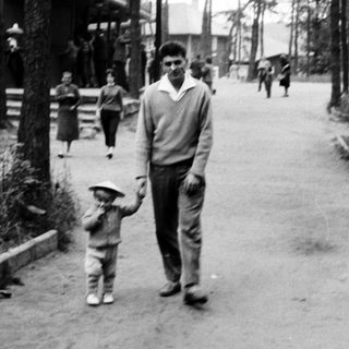 Man and child walking along a wooded path.
