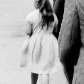 A man walks with a child along a path.