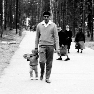 Man walking down a path with a child and others.