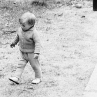 Black and white photo of people walking through a park.