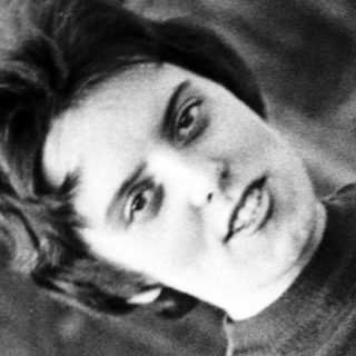 Black and white portrait of a person in a sweater and pants.