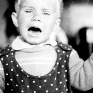 Black and white image of a child with an open mouth.