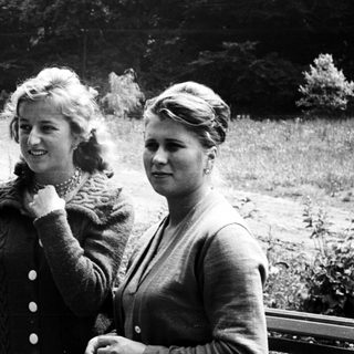 Two young women stand outdoors in a black and white photo.