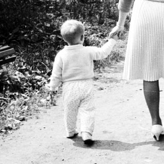 Woman and child walking along a path in a park.