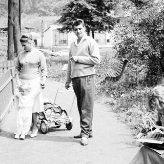 Couple with child strolls along a path in a park.