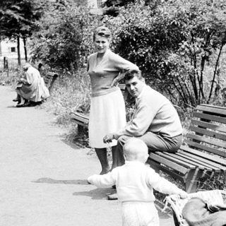Couple and child strolling along a path, vintage scene.