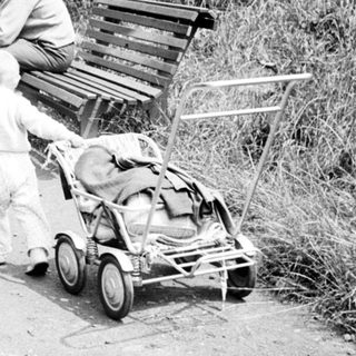 Couple and child strolling along a path, vintage scene.