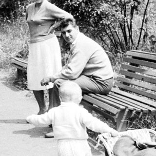Couple and child strolling along a path, vintage scene.