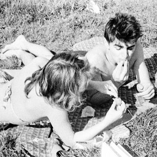 Couple relaxing on a blanket, enjoying a picnic outdoors.