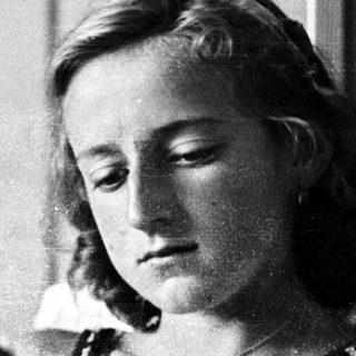 Woman reading sheet music in a vintage black and white photo.