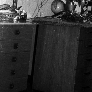 Black and white photo of a decorated Christmas tree indoors.