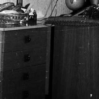 Black and white photo of a decorated Christmas tree indoors.