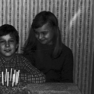 Three children blow out candles on a cake.