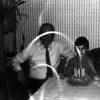 Family gathers around a cake, appearing to celebrate a birthday.
