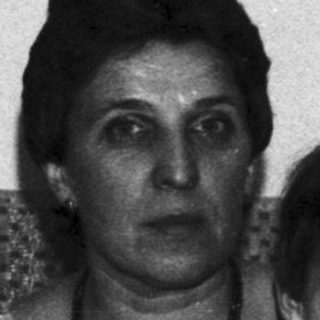 Woman and boy sit in a vintage, patterned room.
