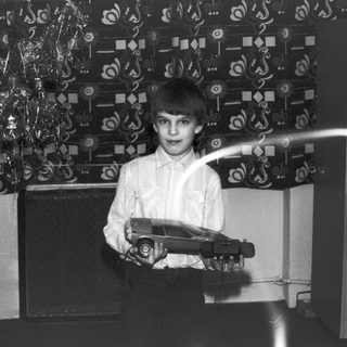 Boy holding toy car, likely a Christmas photo.