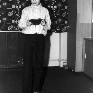 Boy operating a toy car in a room.