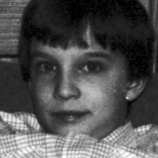 Black and white photo of a child with a teddy bear.