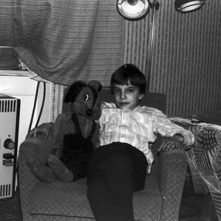 Black and white photo of a child with a teddy bear.
