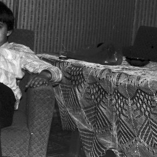 Black and white photo of a child with a teddy bear.
