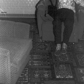 Boy sits on chair, facing camera, in a room.