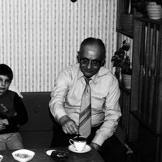 Black and white photo of a family at a table.