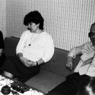 Three people sitting and conversing in a room.