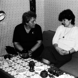 Three people sitting and conversing in a room.