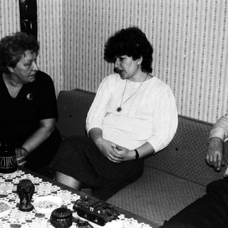 Three people sitting and conversing in a room.