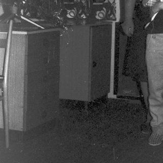 Boy and man stand near decorative streamers and equipment.