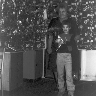 Boy and man stand near decorative streamers and equipment.