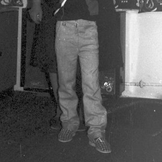 Boy and man stand near decorative streamers and equipment.