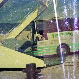 A green bus is parked, with an airplane wing visible.
