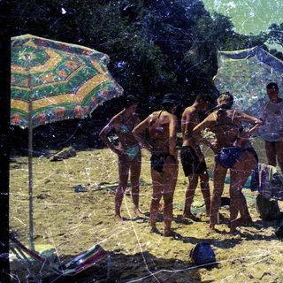 Group of people on a sunny beach with swimwear.
