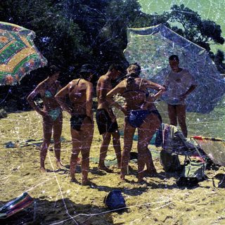 Group of people on a sunny beach with swimwear.