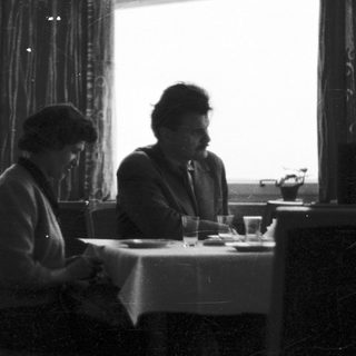 Pair seated at a table in a restaurant setting.