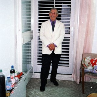 Man stands in a room with a shuttered door.