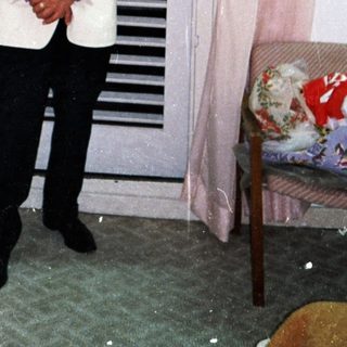 Man stands in a room with a shuttered door.