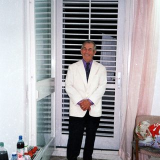 Man stands in a room with a shuttered door.