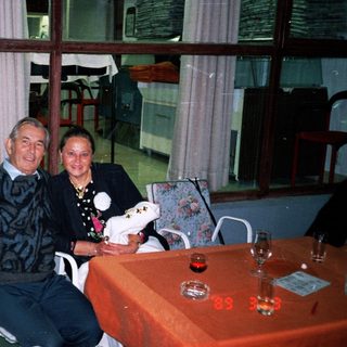Couple sits at table in a restaurant or bar.