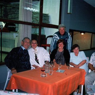 Group of people seated around a table outdoors at night.