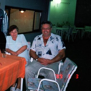 Group of people seated around a table outdoors at night.
