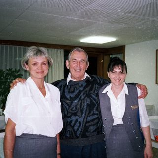 Three people pose for a photo in a restaurant setting.