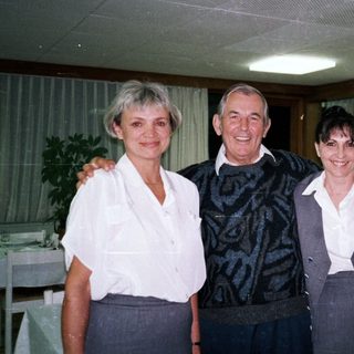 Three people pose for a photo in a restaurant setting.
