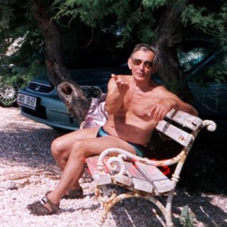 Man relaxes by a beach with coastal scenery.