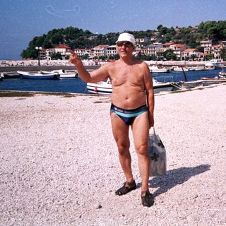 Man on a pebbled beach, holding an object, seaside.