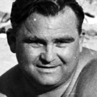 Black and white photo of people on a sandy beach.