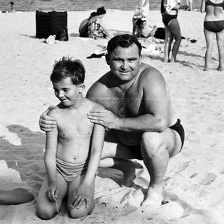 Black and white photo of people on a sandy beach.