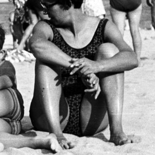 Black and white photo of people on a beach.